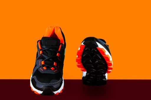 The fashionable running shoes isolated on orange background