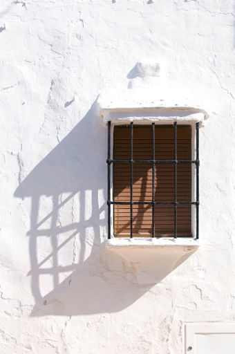 A vertical shot of a window and a white wall in southern Spain