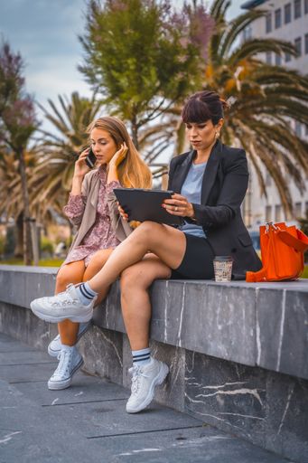 A vertical shot of two young female entrepreneurs outside the office on break from work
