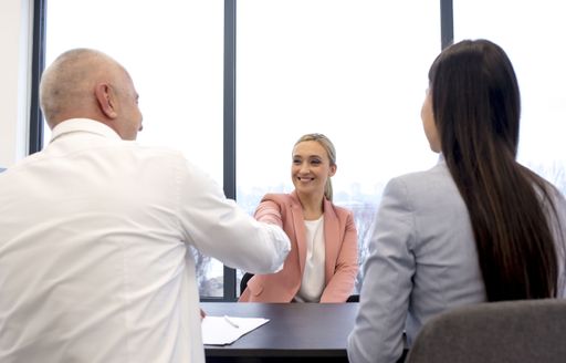 A female job candidate shaking hand with the human resources manager after a successful job interview