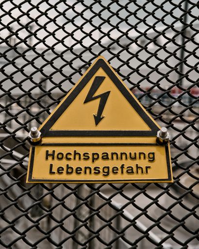 A sign of the high voltage danger to life on a fence