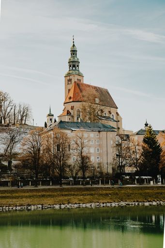 A vertical shot of beautiful architecture of Salzburg, Austria, near the pond on a sunny day
