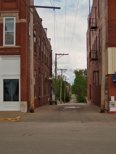 A vertical shot of a narrow alleyway near Paola Park Square in historic Paola Kansas (KS)