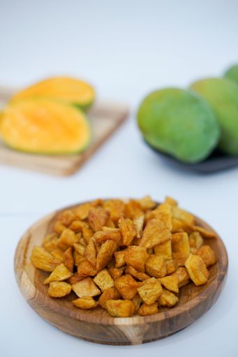 A vertical shot of potato chips in a wooden bowl
