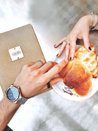 A vertical high angle shot of  a croissant on a table