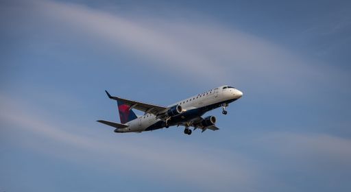 A Delta Airlines plane flying overhead before landing