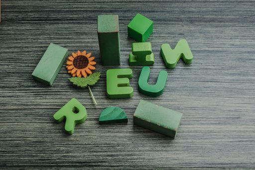 A closeup of green wooden cubes and letters on the table under the lights