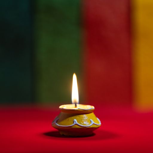A closeup shot of a small yellow handmade candle on a red surface