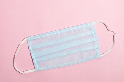 A closeup shot of a protective face mask on a pink background