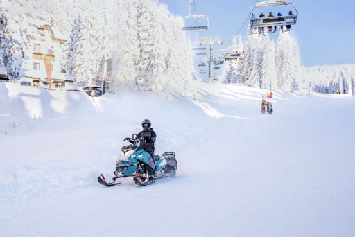 A person riding a snowmobile at a mountain resort