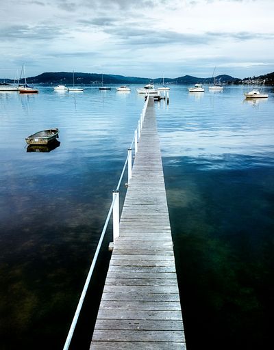 A vertical shot of a pier near the harbor with ships, Sydney, Australia
