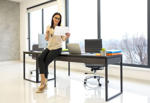 A young female reading a document while sitting on her working table at the office