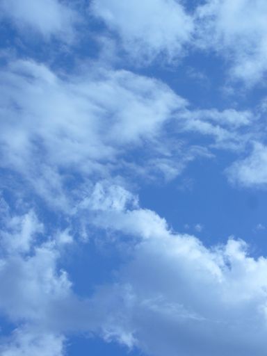A vertical shot of the blue sky with white clouds