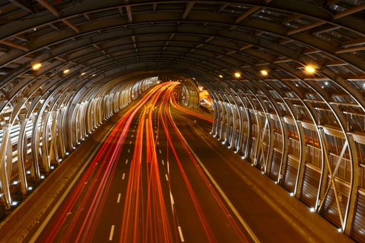 The light trails of cars in an illuminated tunnel