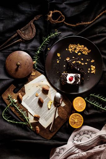 A vertical top view of a messy table with a gourmet plate of cake slices
