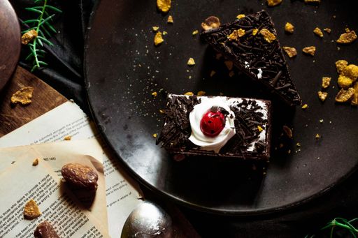 A top view of a black plate with dark chocolate cake slices