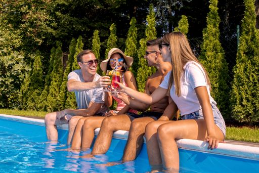 Young Caucasian friends drinking cocktails in the pool