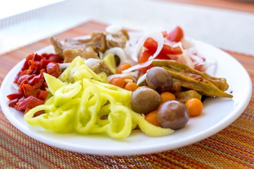 A closeup shot green peppers, red peppers, mushrooms, and other vegetables on a plate