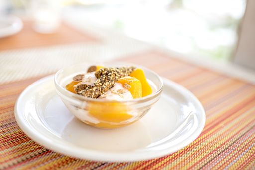 A closeup shot of apricot compote, vanilla cream, toasted sticks with sesame and oat flakes