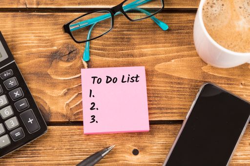 The business desk with pink paper and to-do list