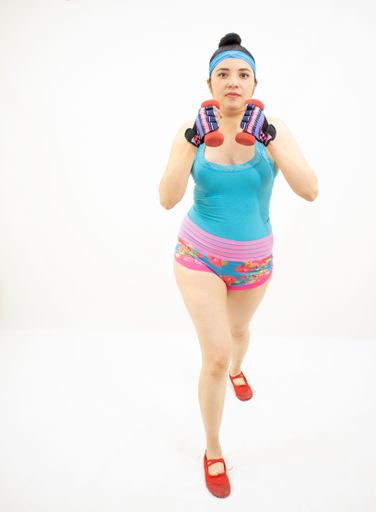 A beautiful athletic woman wearing sporty clothes and working out on a white background