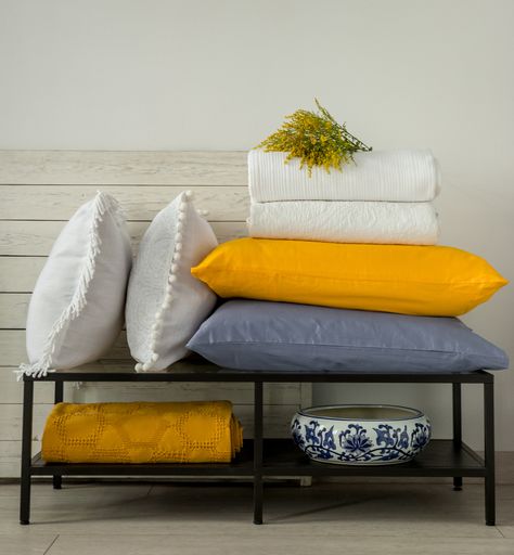Soft yellow and white decorative pillows and blankets in the bedroom