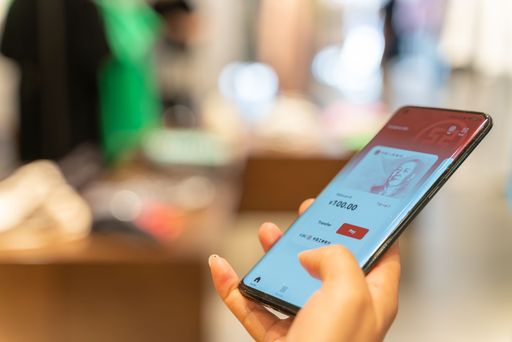 A closeup shot of a Chinese customer using digital currency on a phone when shopping in the mall