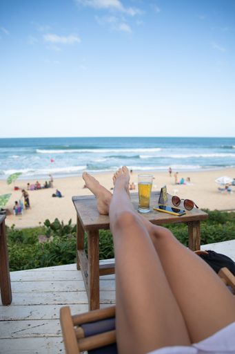 A vertical shot of a female's legs on a table during the vacation in Florianopolis, Brazil