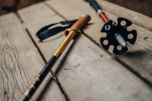 Close up detail photo of trekking poles on wooden background. Hiking telescopic poles. Nordic walking sticks for active outdoor sports.
