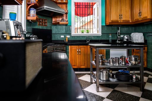 A plaid floor with appliances over and under the counter, radio, extractor, windows ligth coming from the exterior