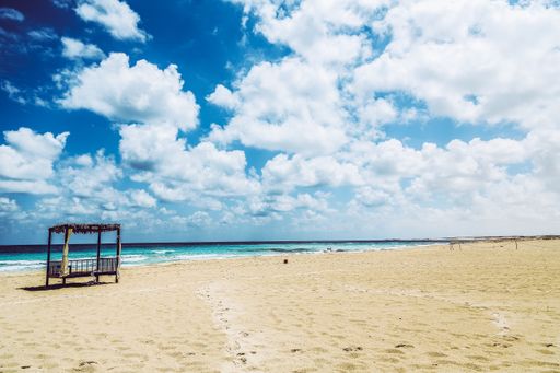 A beautiful shot of a wooden pavilion on the beach with breathtaking clouds in the background