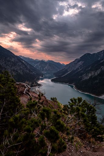 A breathtaking aerial view of mountain lake during dark cloudy sunset