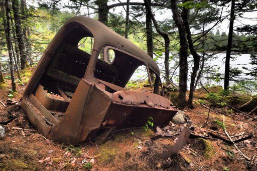 A broken rusted old car parts in the forest