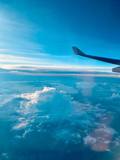 A vertical shot of the view from the airplane window with the beautiful clouds