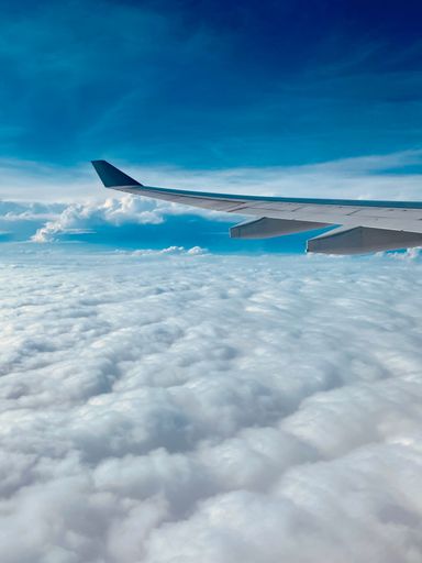 A vertical shot of the view from the airplane window with the beautiful clouds