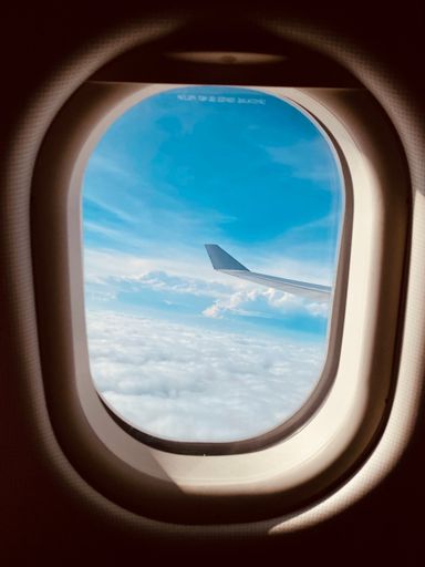 A vertical shot of the view from the airplane window with the beautiful clouds
