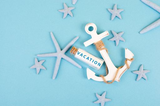 Blue colored summer and holiday background, anchor, sea stars and a glass bootle with the word vacation, travel and tourism concept