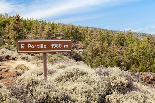 A sign of Portillo signal on the Mount Teide with plants under blue sky, Spain