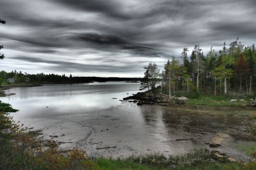 A lake and a cloudy dark sky over it in Canada