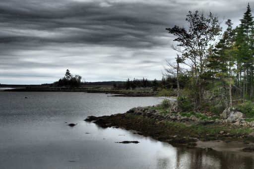 A lake and a cloudy dark sky over it in Canada