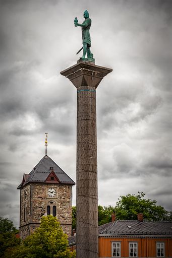 The Saint Olav statue and Var Frue Church tower against a gloomy sy