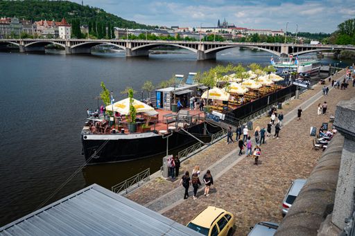 A boat restaurant on the Vltava and Jirasek Bridge in the background, Prague, Czech Republic