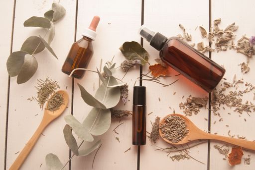 A beautiful flat lay with various spices and natural leaves with empty flasks in the center, perfumery concept