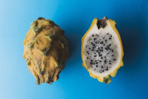 A closeup shot of a yellow pitaya isolated on blue background