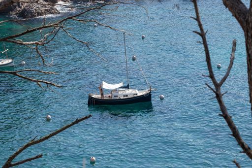 A high angle shot of a floating boat on blue water near Palamos, Spain