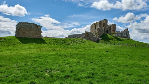 Spectacular view of ruins of Duffus Castle located in green valley on grassy hill near Elgin Moray, Scotland under blue cloudy sky