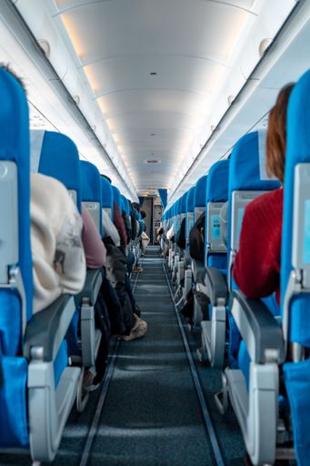 An aircraft cabin with rows of seats down the aisle