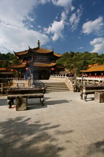 A vertical shot of the temple in Kunming, China with incense burners at the front