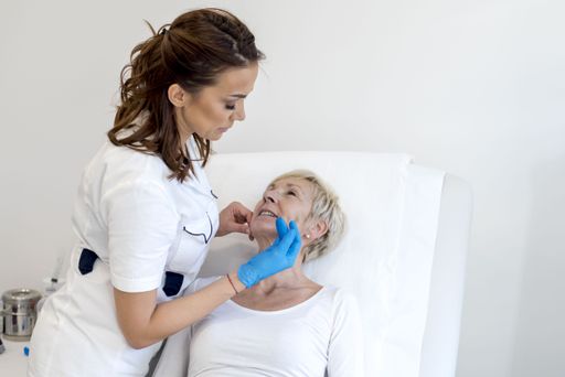 The doctor checking an old female's face before performing cosmetic surgery