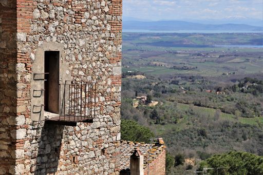 A beautiful view the green fields and blue sky from a medieval stone old house in Montepulciano town on a sunny day in Siena Province, Tuscany, Italy